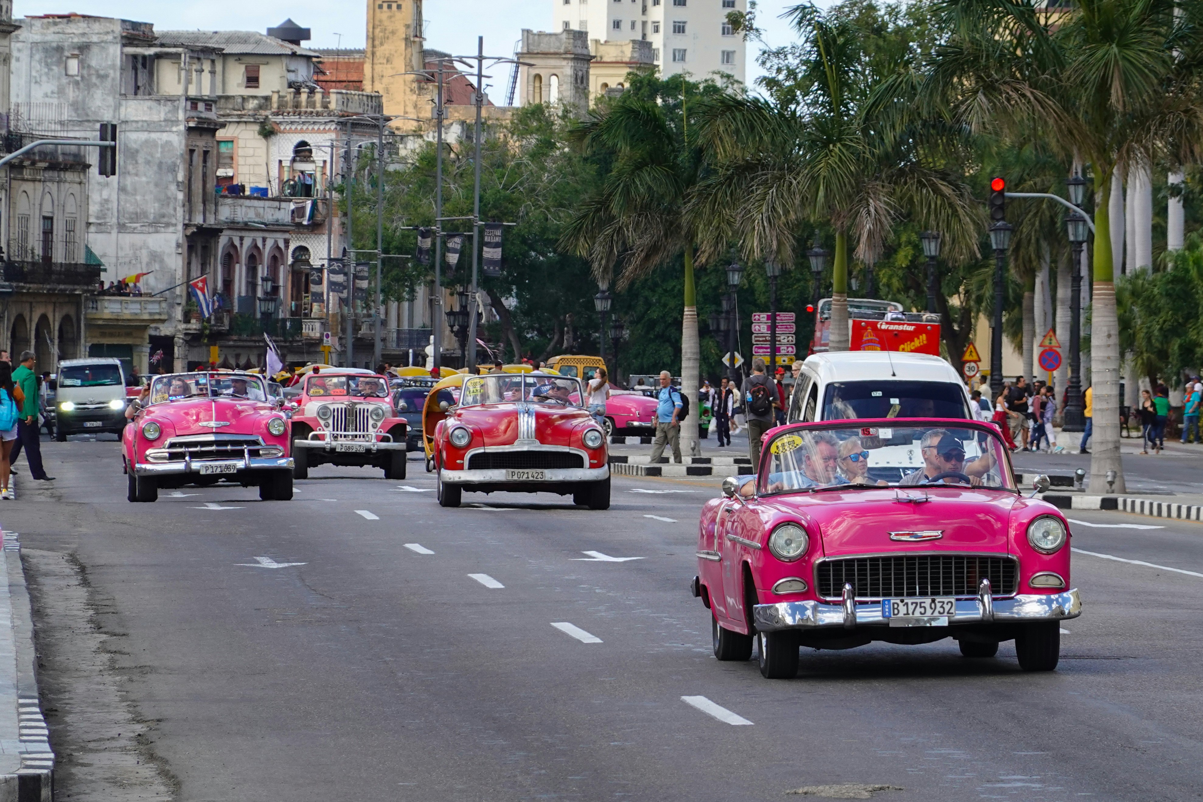 red and white cars on road near buildings during daytime